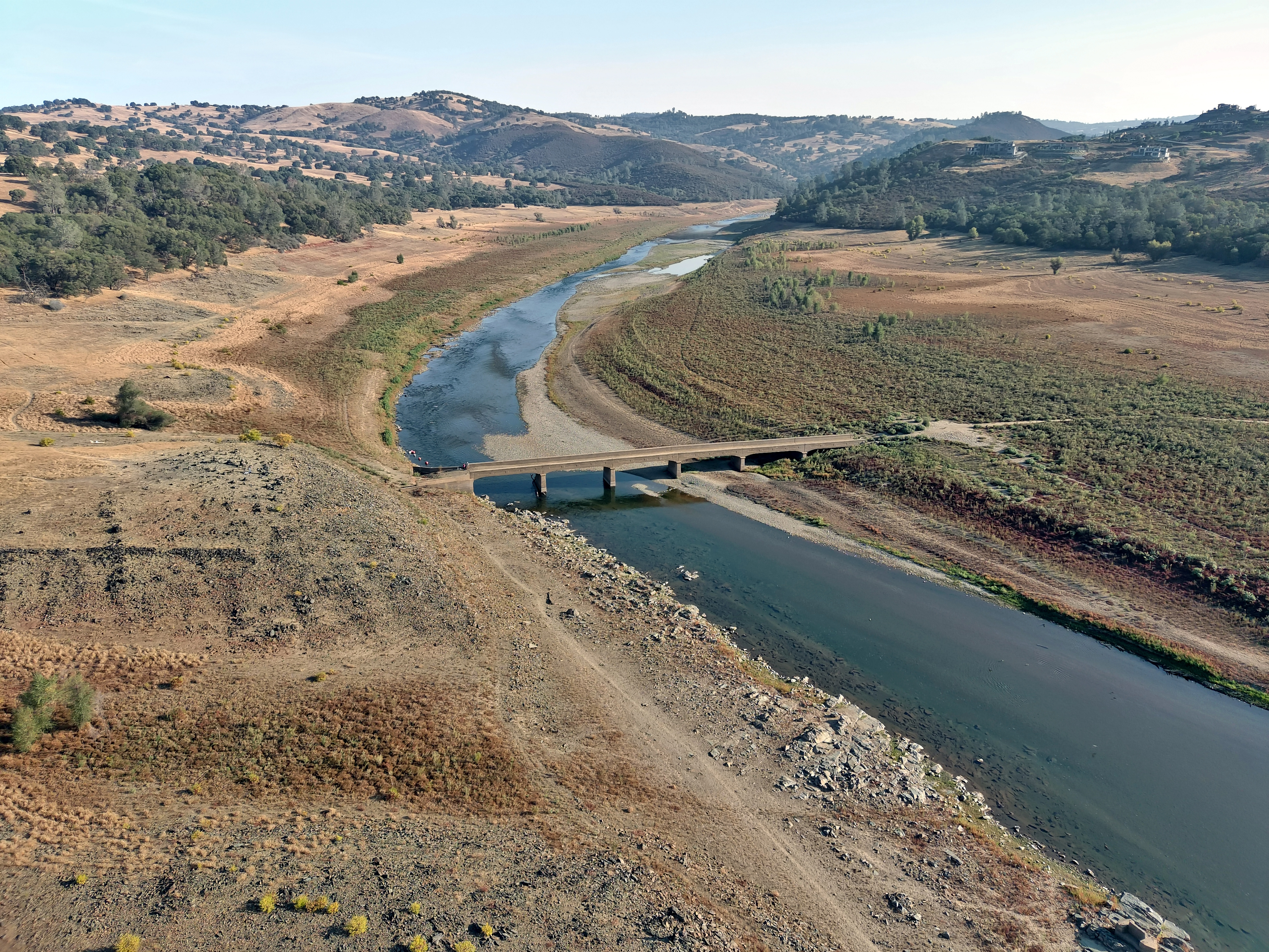 A thumbnail of a drying up creek bed with a small amount of water surrounded by dirt with a bridge running across, which provides more information on the topic Changes in rainfall 